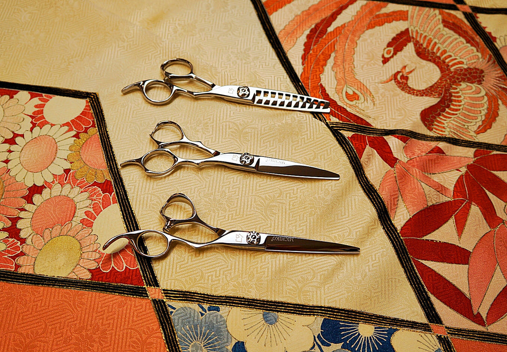 Professional Japanese hairdressing scissors set on traditional kimono fabric, including thinning shears and precision cutting shears for salon and stylist use.