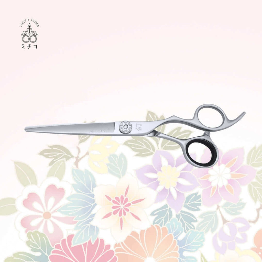 MICHIKO NIGATA 6.0-inch authentic Japanese hairdressing scissors in a closed position, showing the MICHIKO letter logo on the cutting blade and an illustrative logo under the screw area.