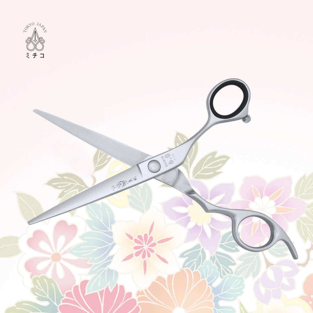 Authentic Japanese NIGATA 6-inch barber shears in an open position, showing the back side with a traditional Japanese lady in a Kimono as the MICHIKO symbol on the blade. Under the screw area, the model name, size, and serial number are visible.