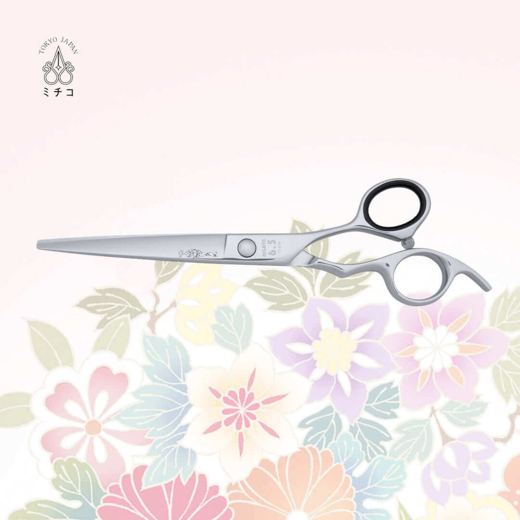 MICHIKO NIGATA 6.5-inch barber shear in a closed position, showing the back side with a traditional Japanese lady in a Kimono as the MICHIKO symbol on the blade. Under the screw area, the model name, size, and serial number are visible.