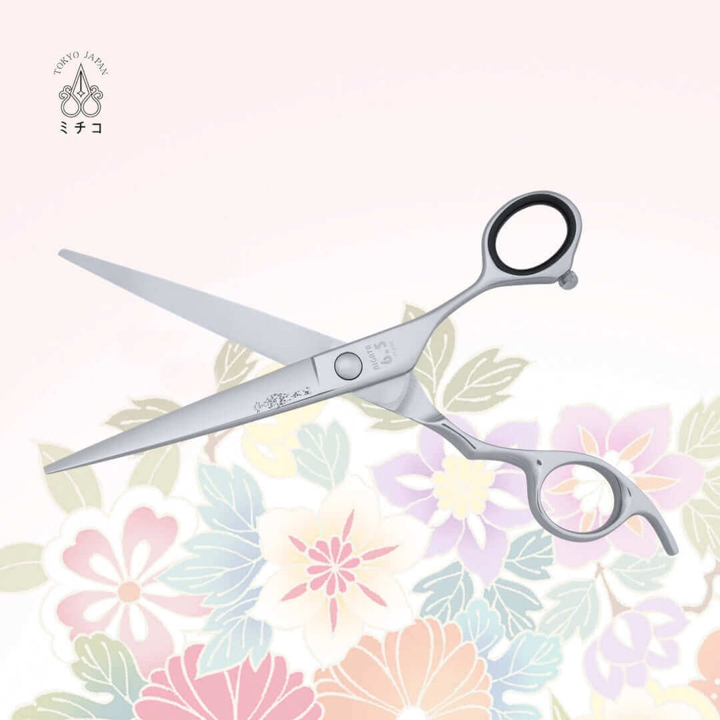 Authentic Japanese NIGATA 6.5-inch barber shears in an open position, showing the back side with a traditional Japanese lady in a Kimono as the MICHIKO symbol on the blade. Under the screw area, the model name, size, and serial number are visible.