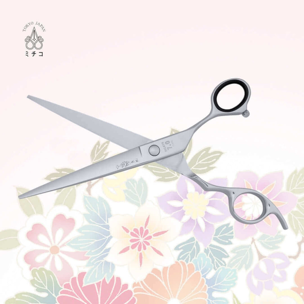 Authentic Japanese NIGATA 7.0-inch hair scissors in an open position, showing the back side with a traditional Japanese lady in a Kimono as the MICHIKO symbol on the blade. Under the screw area, the model name, size, and serial number are visible.